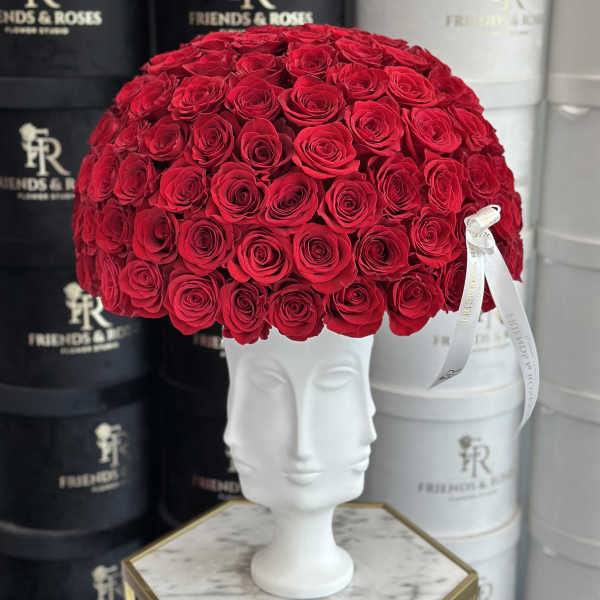 Large dome of red roses in a white sculpted vase