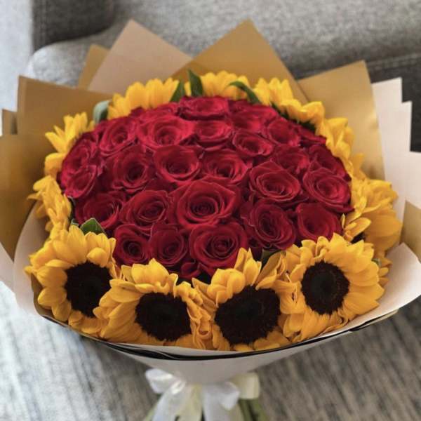 Bouquet of red roses surrounded by yellow sunflowers