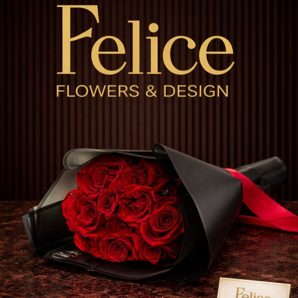 Bouquet of red roses wrapped in black paper with a red ribbon