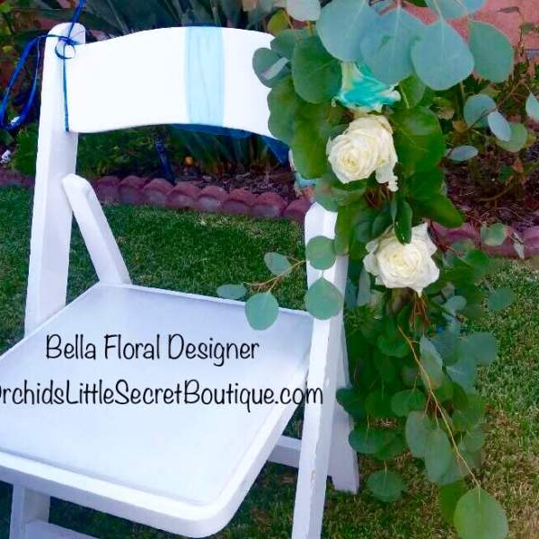 White chair decorated with eucalyptus and white roses