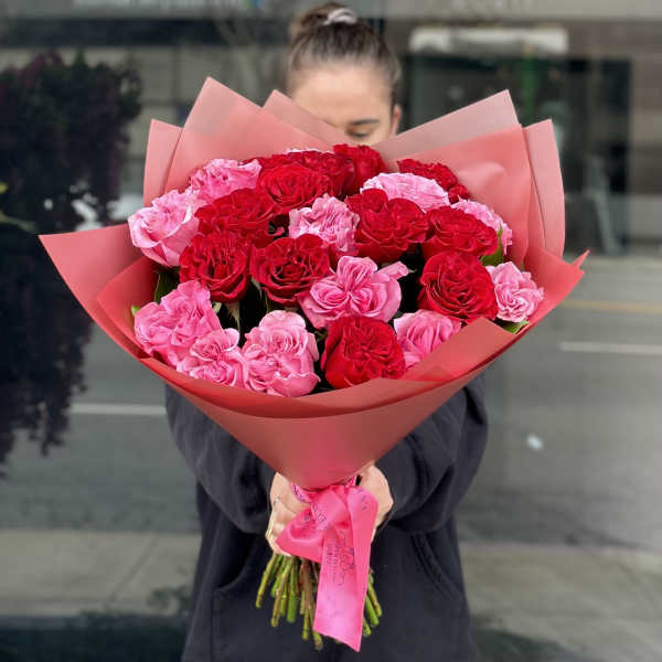 Bouquet of red and pink roses wrapped in pink paper