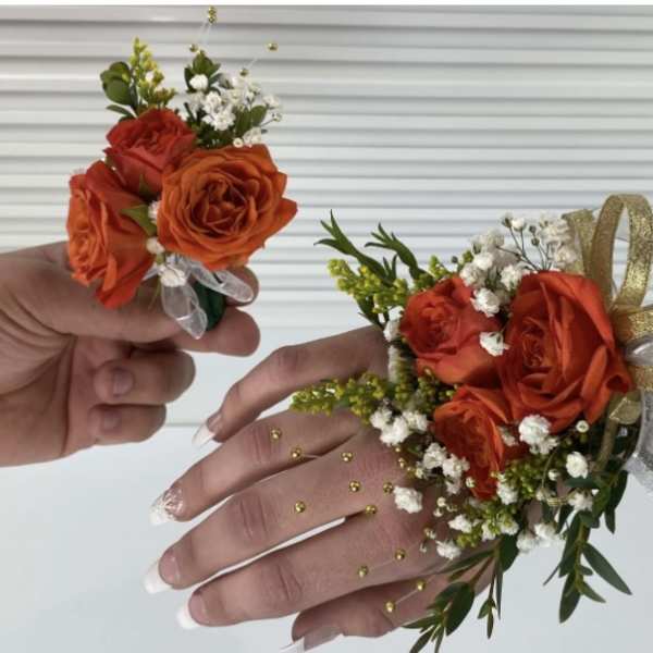 Orange rose corsages with white baby's breath and gold ribbon