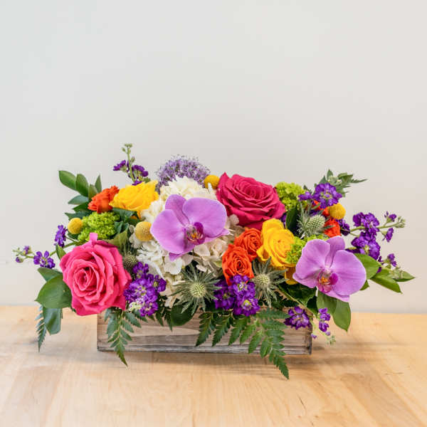 Mixed bouquet in a rustic wooden box with pink roses and purple orchids