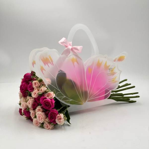 Bouquet of pink and blush roses in a decorative gift bag
