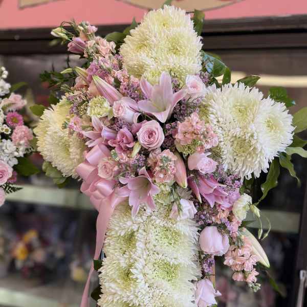 Pink and white floral standing spray with ribbon on an easel