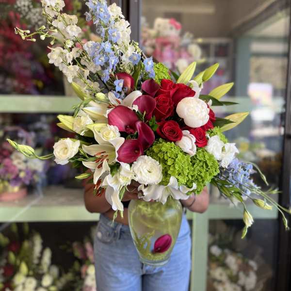 Extravagant Burgundy Calla Lily And Blue Delphinium Arrangement