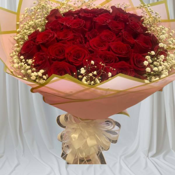 Large bouquet of red roses with baby's breath in pink wrapping