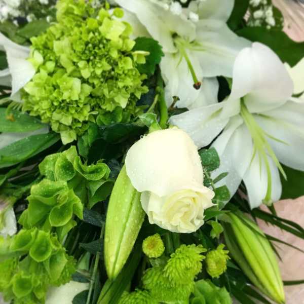 White lilies and green flowers in a bouquet