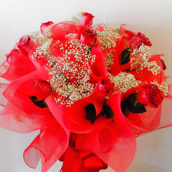 Red roses with white baby's breath in a clear vase