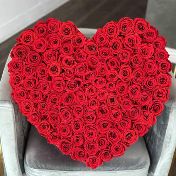 Heart-shaped arrangement of red roses on a chair