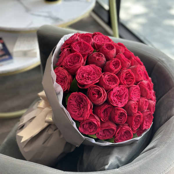 Bouquet of bright pink roses wrapped in paper