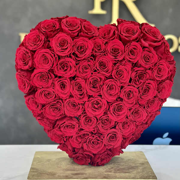 Heart-shaped arrangement of red roses on a gold base