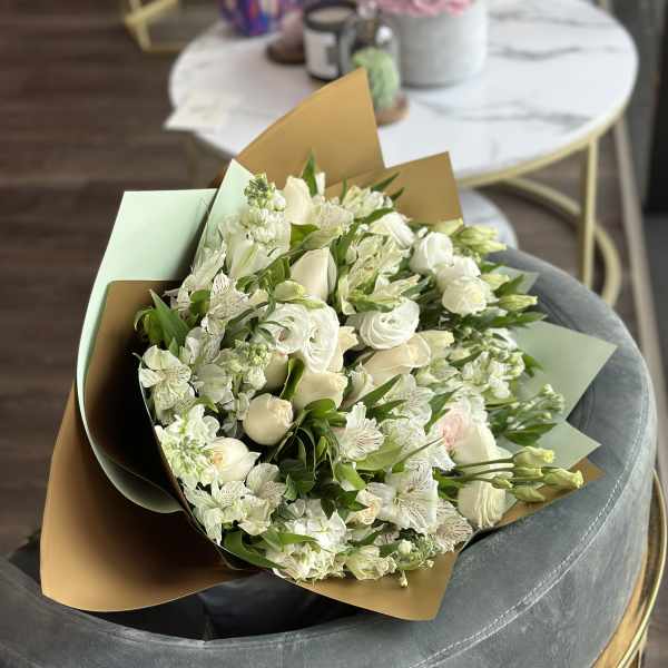 White bouquet with roses and alstroemeria wrapped in brown and mint paper