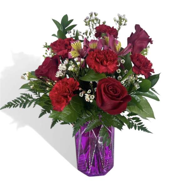 Red roses and carnations in a purple glass vase