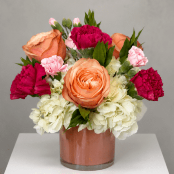 Peach and pink flowers arranged in a glass vase