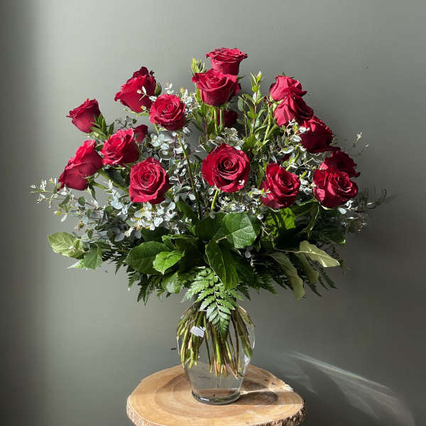 Tall bouquet of red roses in a clear glass vase