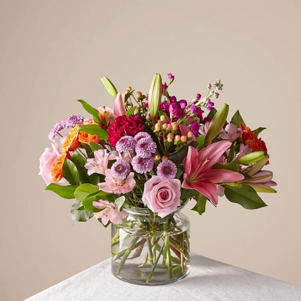 Mixed pink and purple flower bouquet in a clear glass vase