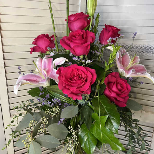 Bouquet of hot pink roses and pink lilies in a glass vase