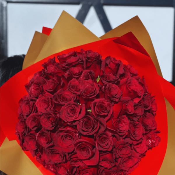Large bouquet of red roses wrapped in layered red and gold paper