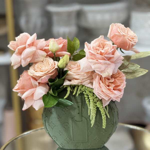 Pink roses arranged in a green patterned vase
