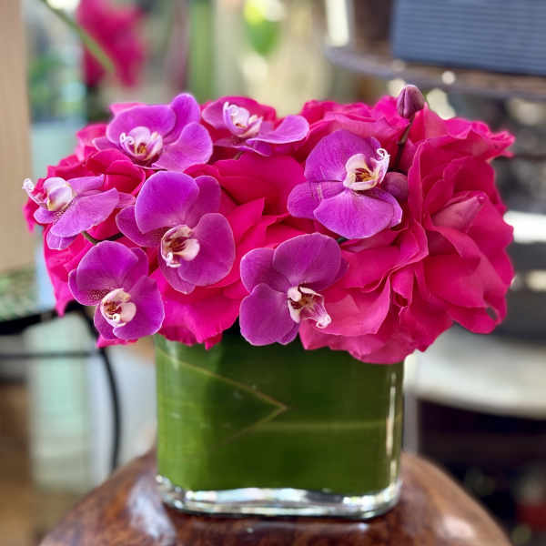 Pink roses and purple orchids in a glass vase