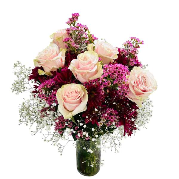 Bouquet of pale pink roses and burgundy daisies in a glass vase