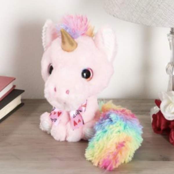 Pink unicorn plush toy with rainbow mane and tail