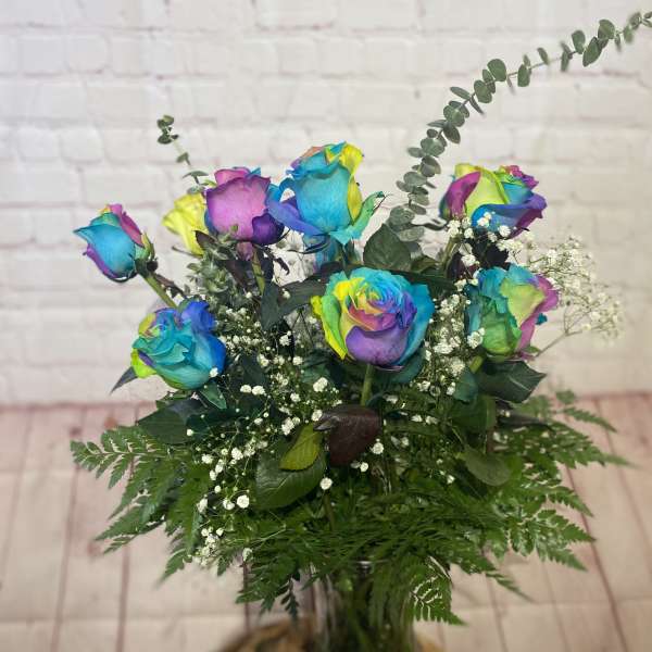 Bouquet of rainbow-colored roses in a glass vase