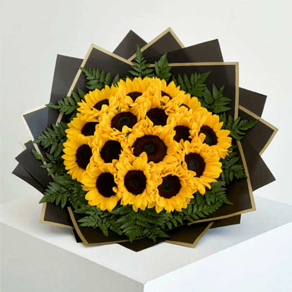 Bouquet of yellow sunflowers with dark centers and fern accents