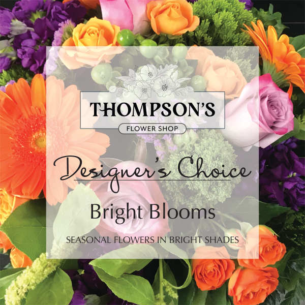 Bright mixed arrangement of orange gerbera daisies, roses, and purple flowers with a text overlay.
