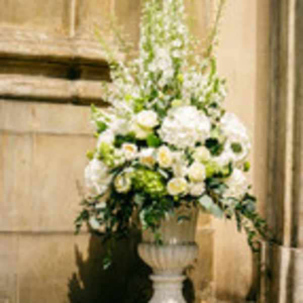Tall white floral arrangement in a pedestal urn
