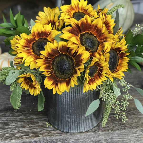 Sunflower arrangement in a black ribbed container