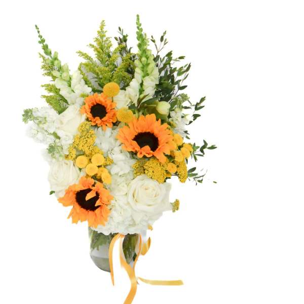 Bouquet of white flowers with orange sunflowers in a glass vase