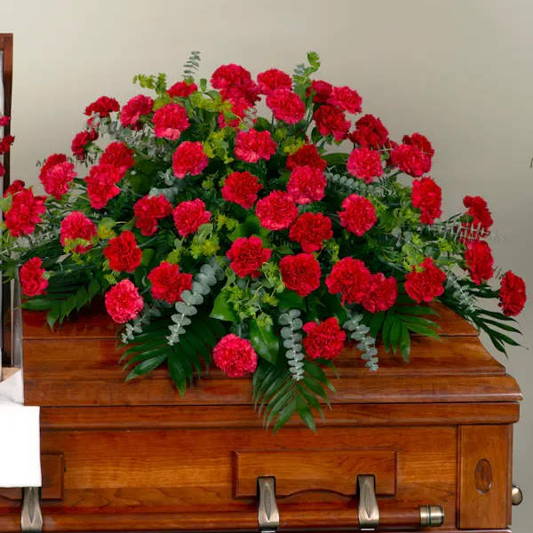 Red carnation arrangement on a wooden casket