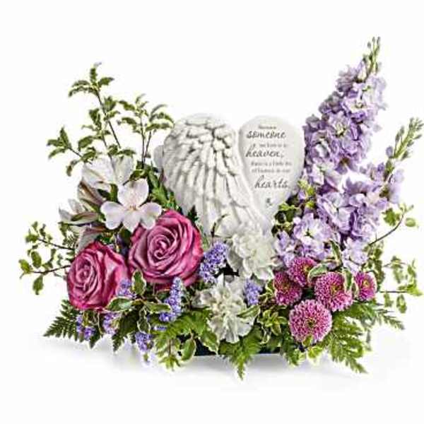 Pink roses and lavender flowers arranged around angel figurines
