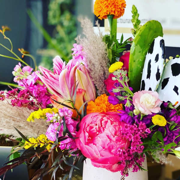 Colorful mixed bouquet in a white vase with pink and orange blooms