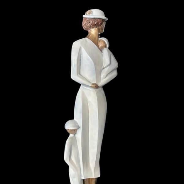 White figurine of a woman holding a child with two small children at her feet