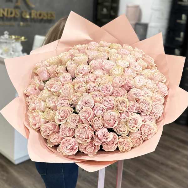 Large bouquet of pale pink roses wrapped in blush paper