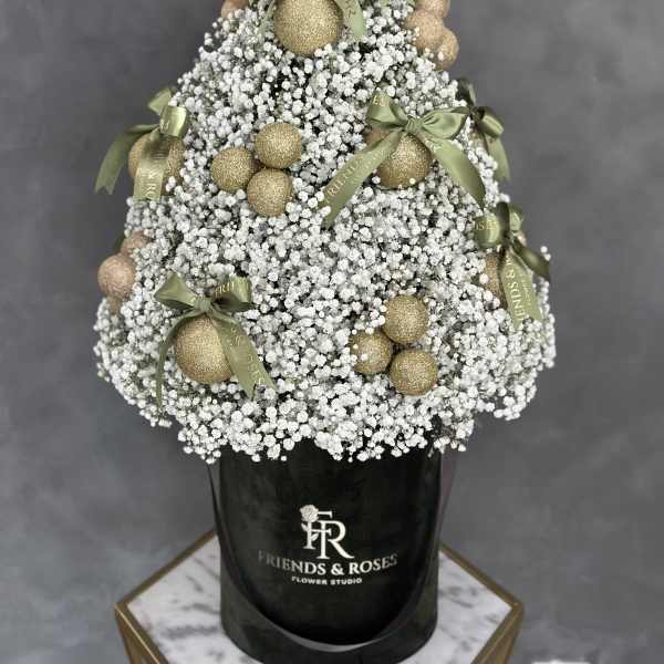 White baby's breath arrangement with gold ornaments and green bows in a black box