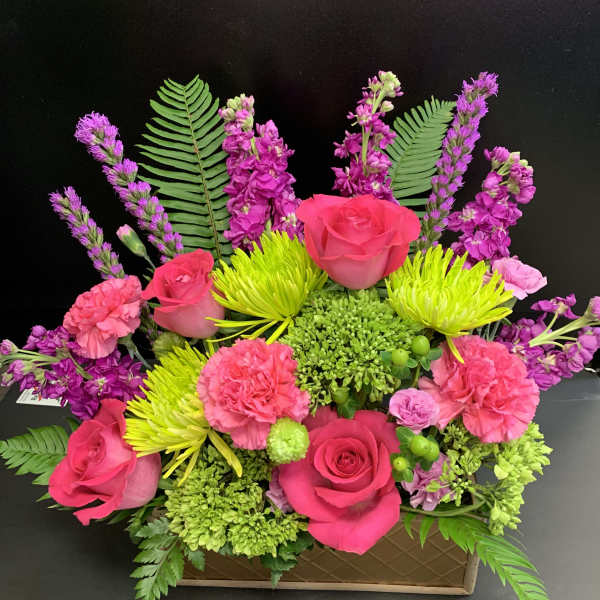 Bright pink roses and carnations in a low rectangular box