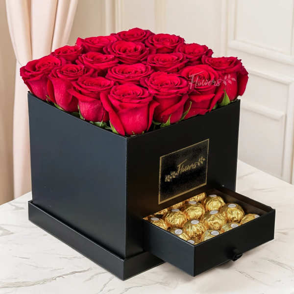 Red roses in a black box with a drawer of gold-wrapped chocolates.