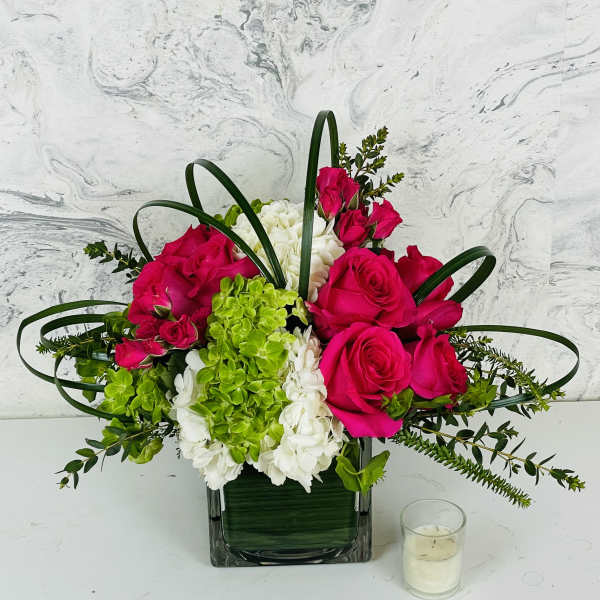 Pink roses and green-white hydrangeas in a square glass vase