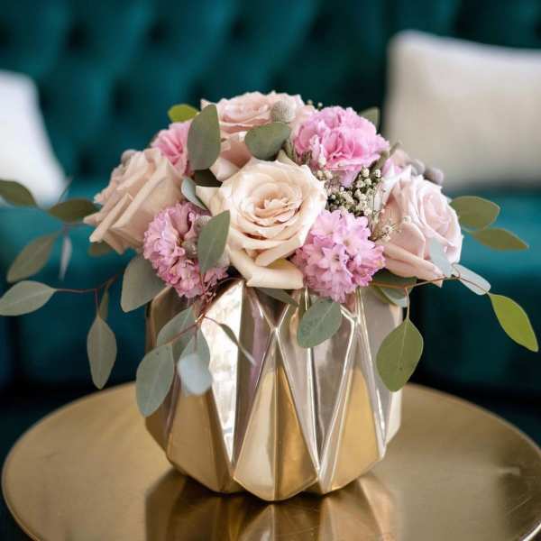 Pink and cream roses in a faceted gold vase