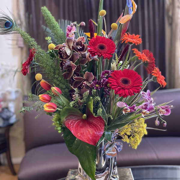 Colorful tropical flower arrangement in a clear glass vase
