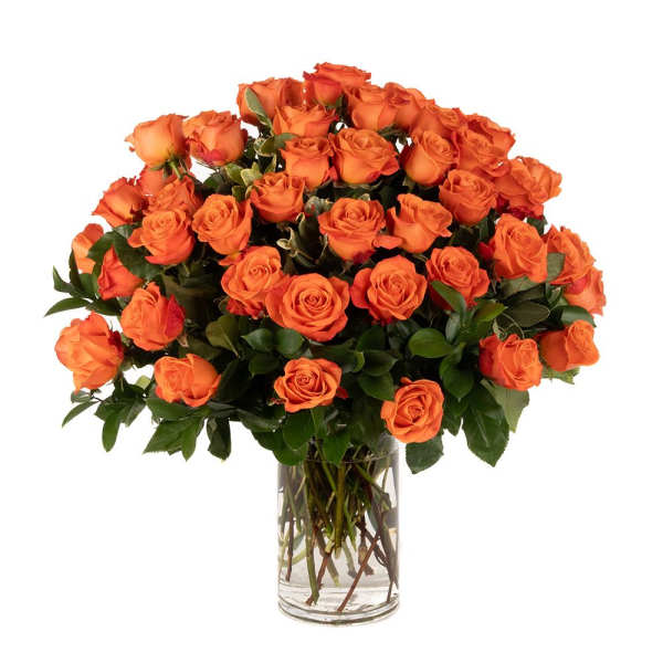 Large arrangement of orange roses in a clear glass cylinder vase