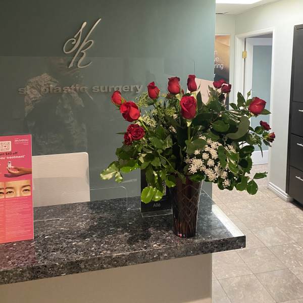Red roses in a dark glass vase on a counter