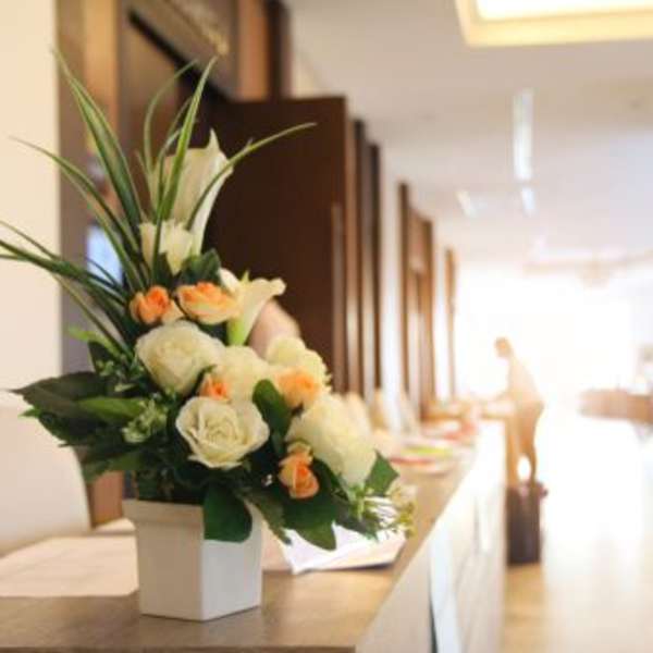 White and peach floral arrangement in a square vase