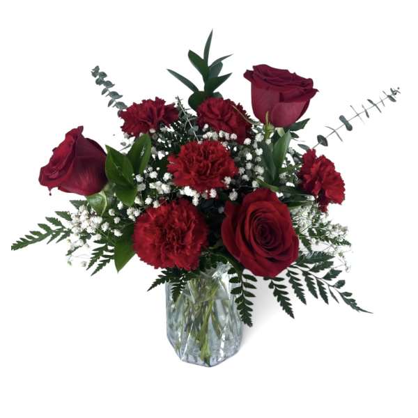 Red roses and carnations in a clear glass vase