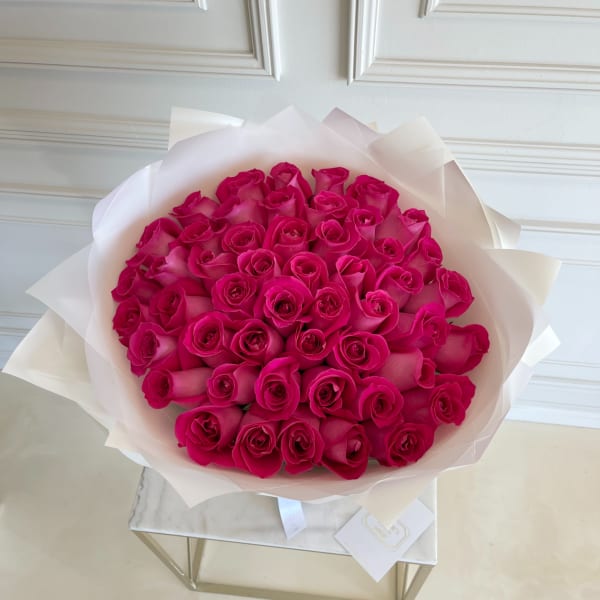 Bouquet of hot pink roses wrapped in white paper