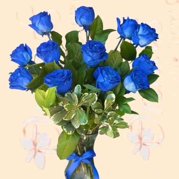Blue roses in a glass vase with a ribbon